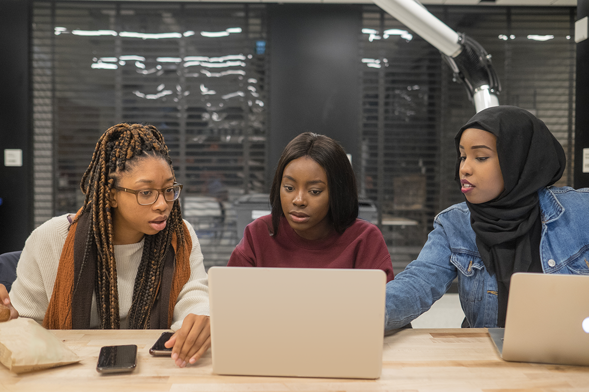 3 students at a laptop in a study room