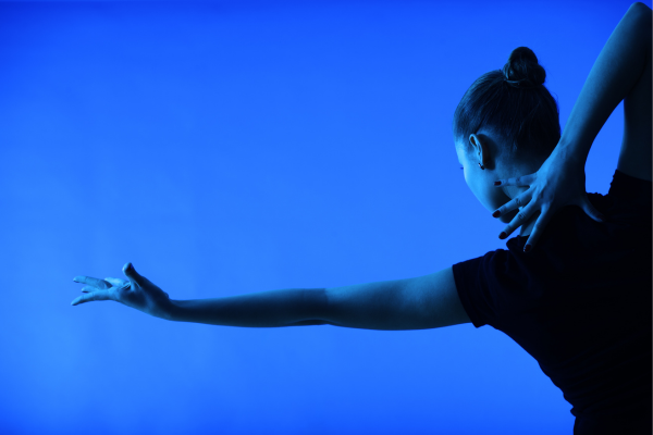 Woman dancing against blue background